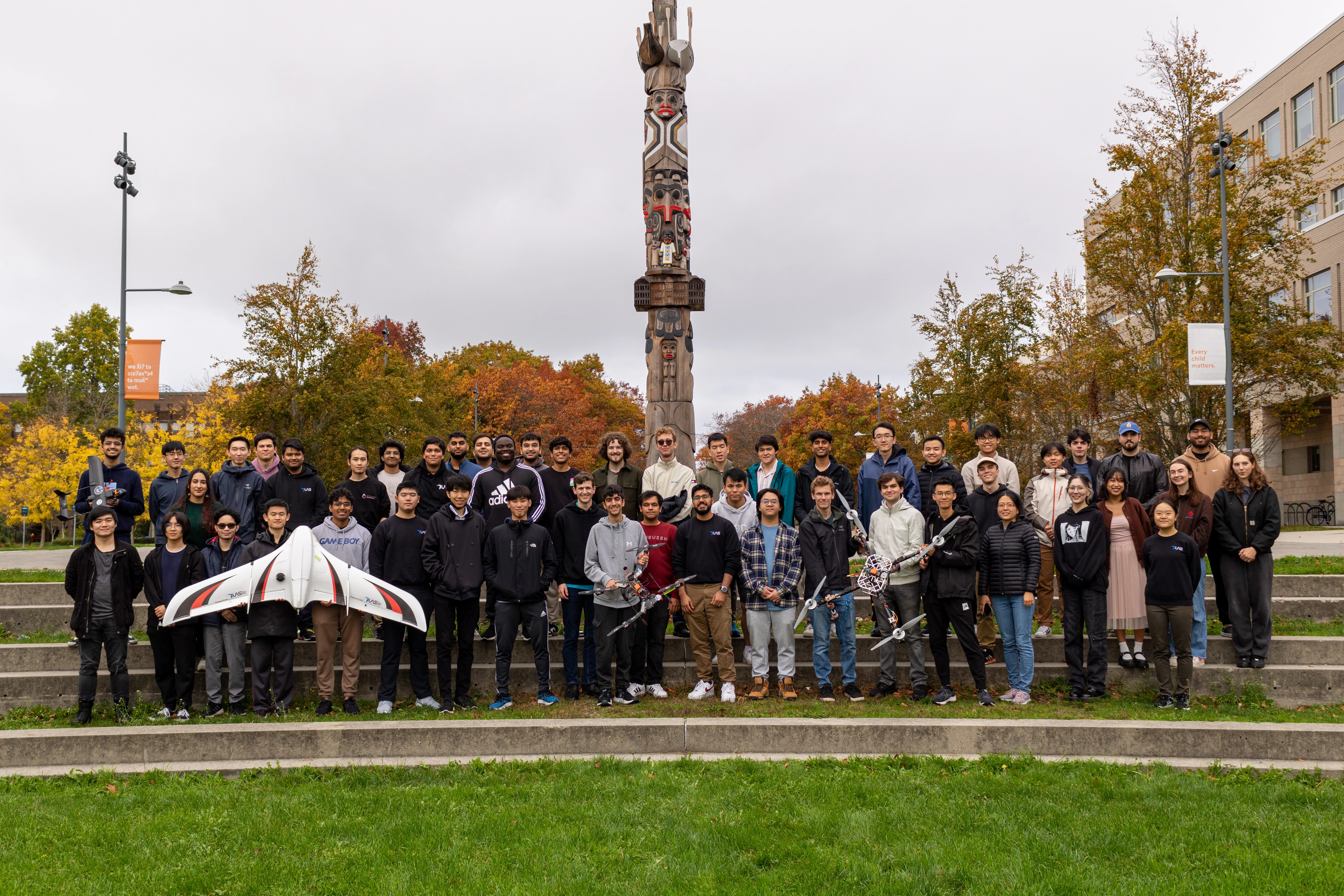 Happy team members holding a few of the team drones